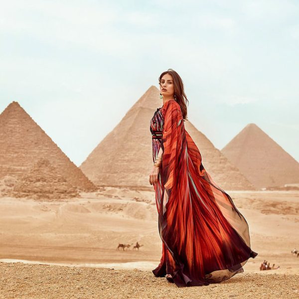 A-wonderful-picture-of-a-girl-wearing-a-red-dress-standing-in-front-of-the-pyramids